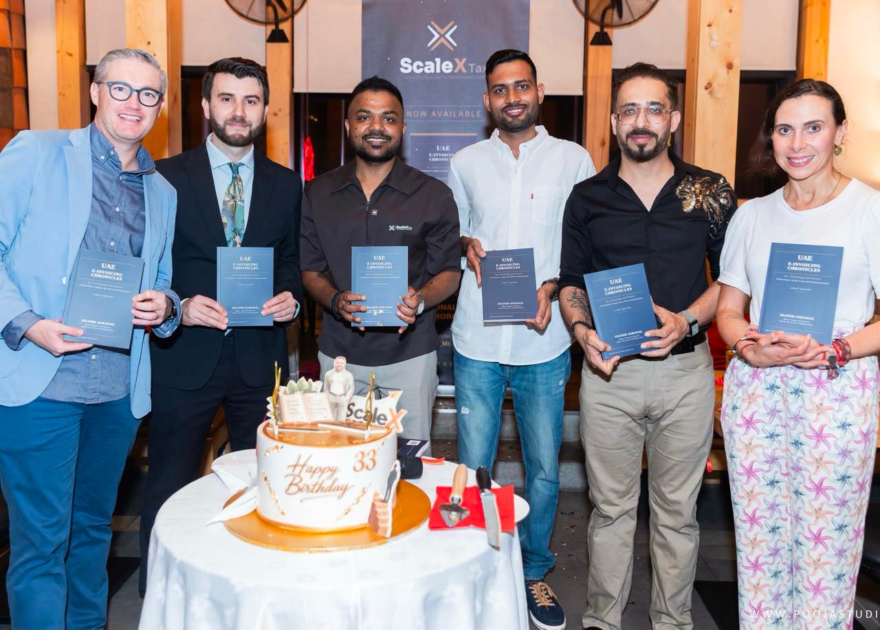 Guests holding the UAE E-Invoicing Chronicles book at the ScaleX Tax launch party